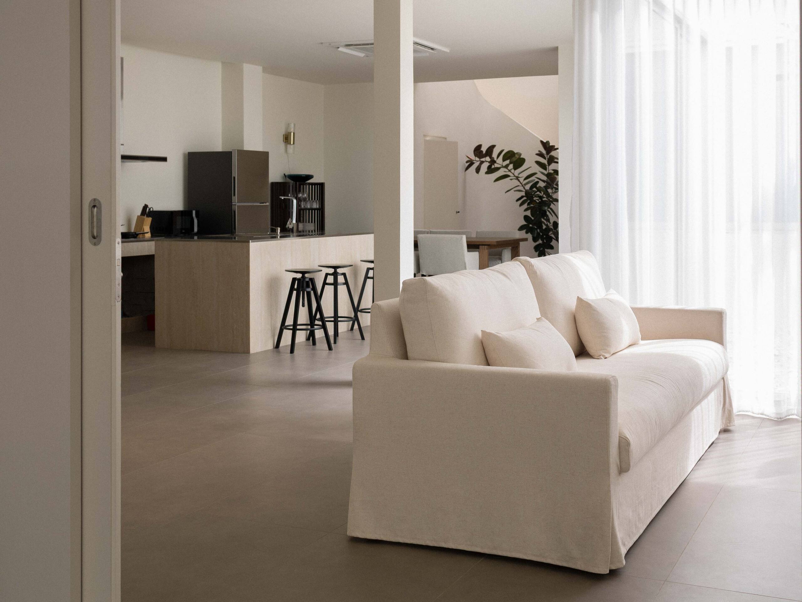 White sofa in the open-plan lounge beside the kitchen