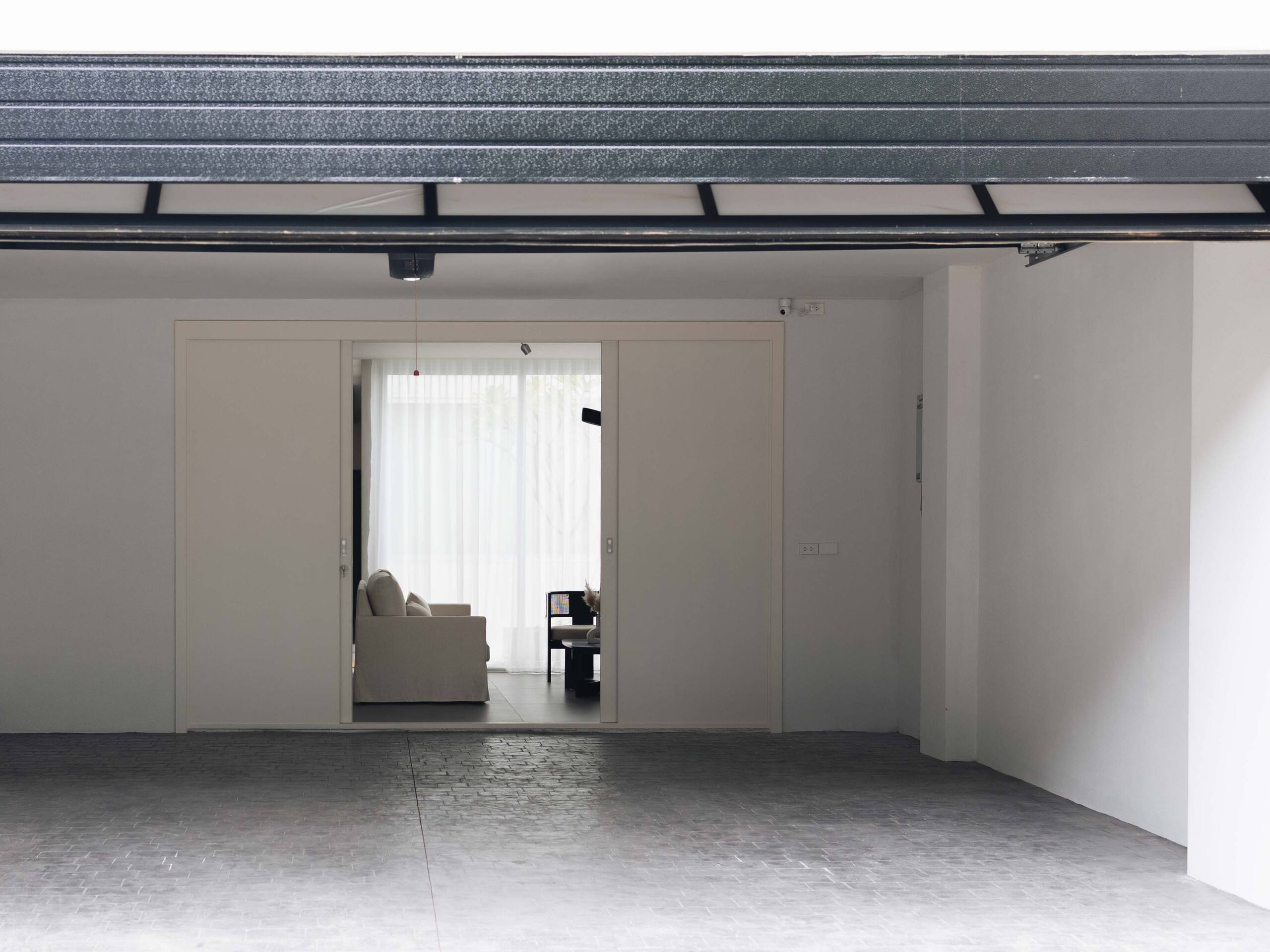 Original photo of the white sliding doors open between the garage and living room