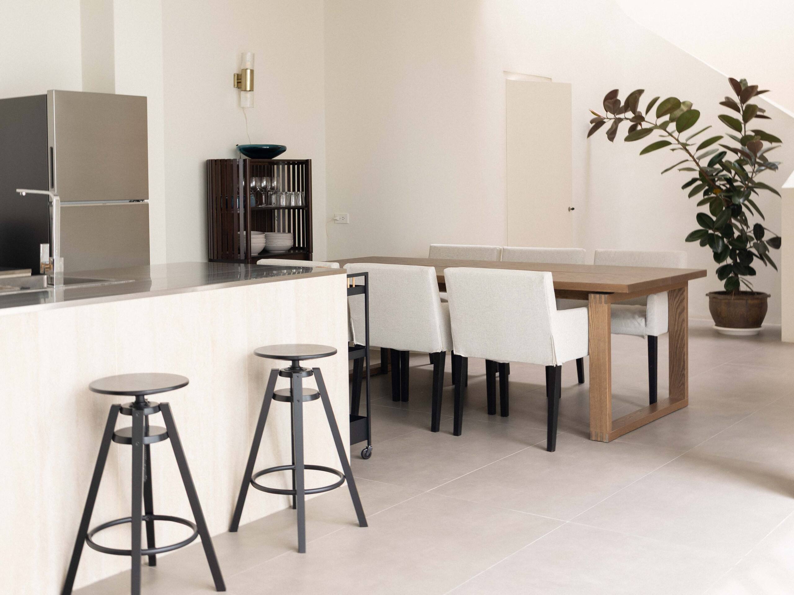 Aube’s kitchen and dining space, with natural textures and a view through the courtyard